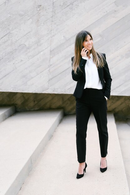 Foto empresaria sonriente en traje hablando por teléfono