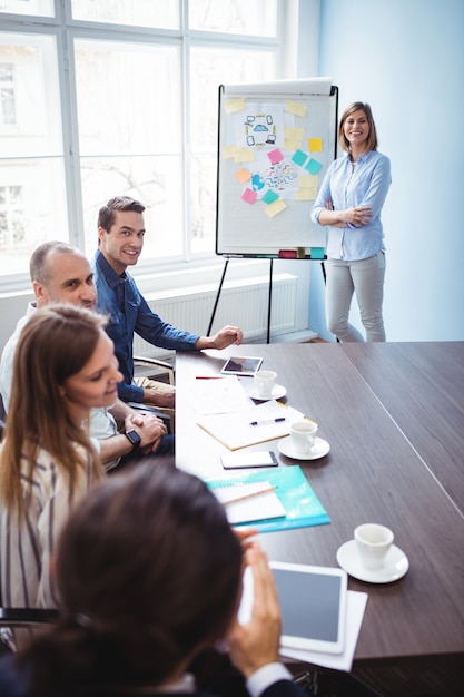 Empresária sorridente com colegas de trabalho na sala de reuniões