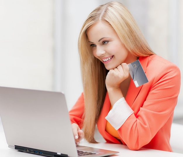 empresária sorridente com laptop e cartão de crédito