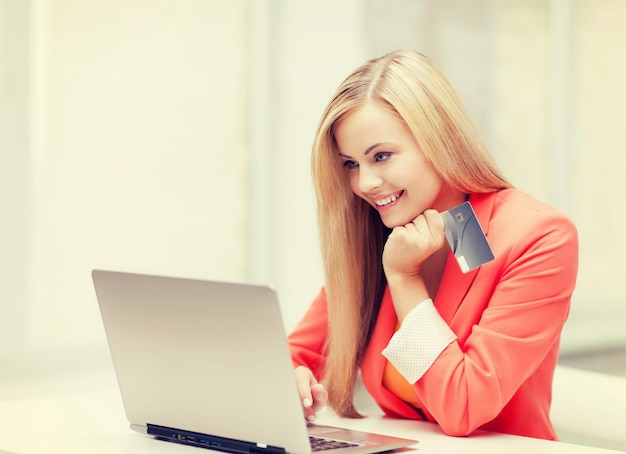 empresária sorridente com laptop e cartão de crédito