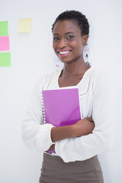 Empresária sorridente segurando um caderno