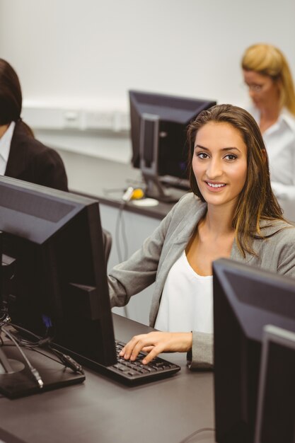 Empresária sorridente trabalhando na sala de informática