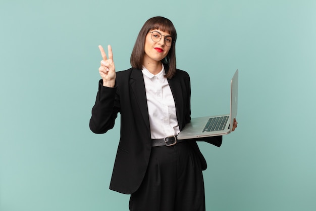 Empresária sorrindo e parecendo amigável, mostrando o número dois ou o segundo com a mão para a frente, em contagem regressiva