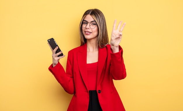 Empresária sorrindo e parecendo amigável, mostrando o número três. conceito de smartphone