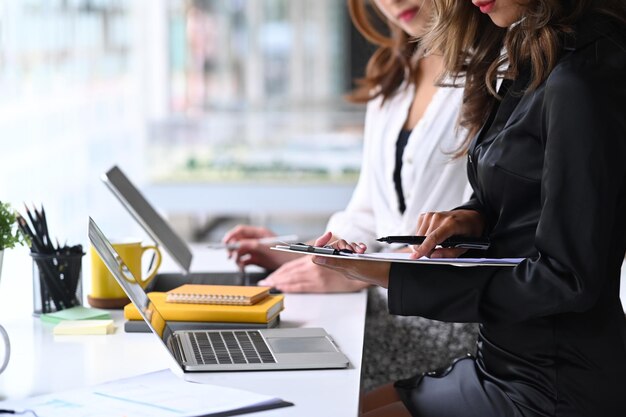 Foto empresaria sosteniendo documentos y compartiendo ideas o planes de negocios de inicio con su colega