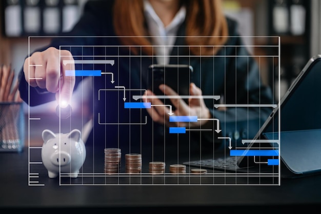 Empresaria sosteniendo monedas poniendo en vidrio con el uso de un teléfono inteligente y una calculadora para calcular el concepto de ahorro de dinero para la contabilidad financiera