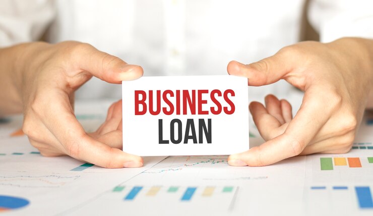 La empresaria sosteniendo una tarjeta con texto PRESTAMO COMERCIAL