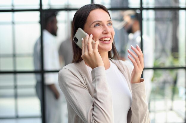 Empresaria con teléfono en la oficina moderna