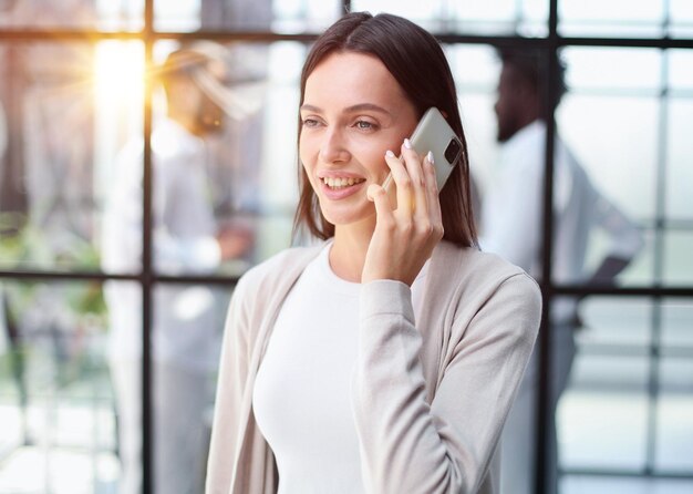 Empresaria con teléfono en la oficina moderna