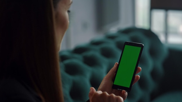 Empresária tendo chamada de vídeo no smartphone com tela verde