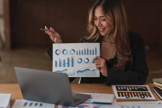 Empresária tendo uma videochamada no laptop enquanto discute com o parceiro de negócios