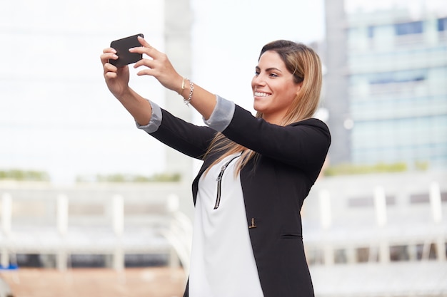 Empresária tirar uma selfie no ambiente urbano