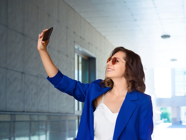 empresaria tomando una foto con un teléfono inteligente