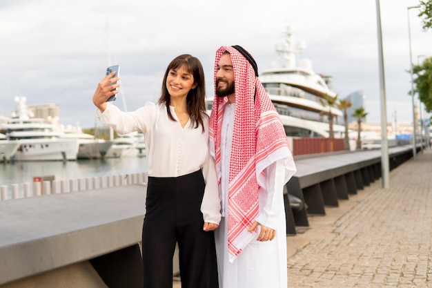 La empresaria tomando selfie con hombre árabe