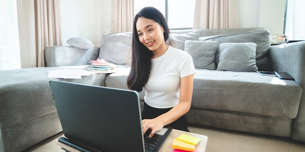 La empresaria trabaja con computadora portátil desde casa, persona mujer que trabaja con tecnología y negocios de comunicación en línea, escritorio de trabajo con portátil interior aislado en una casa