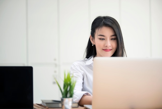 Empresaria trabajando con la computadora portátil en la oficina moderna