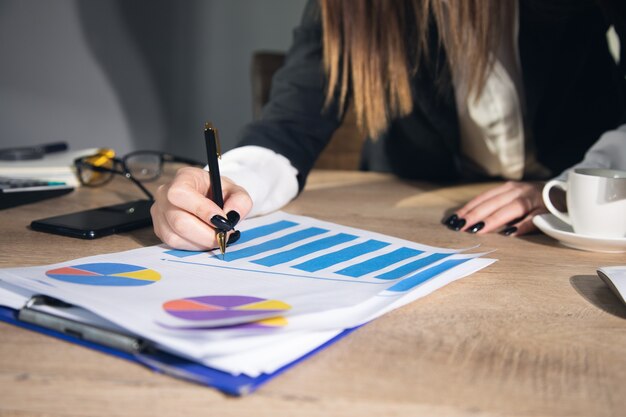 Empresaria trabajando con gráficos y tablas en la oficina.