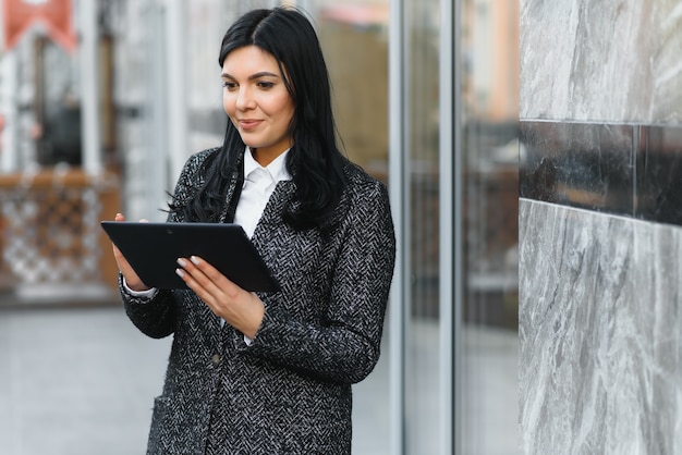 La empresaria trabajando en tableta digital al aire libre