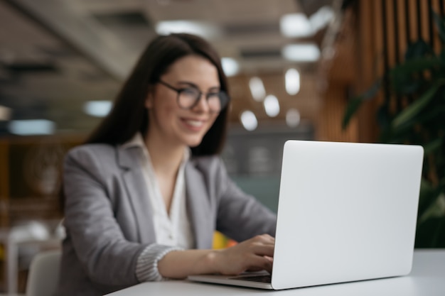 Empresária, trabalhando no escritório, foco no laptop