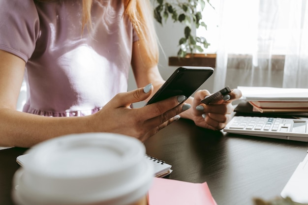 Empresaria a través de teléfono móvil en la oficina moderna