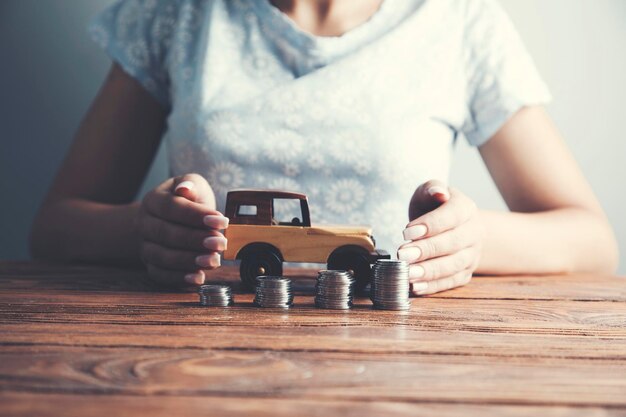 Empresária, um carrinho de brinquedo e uma pilha de moedas