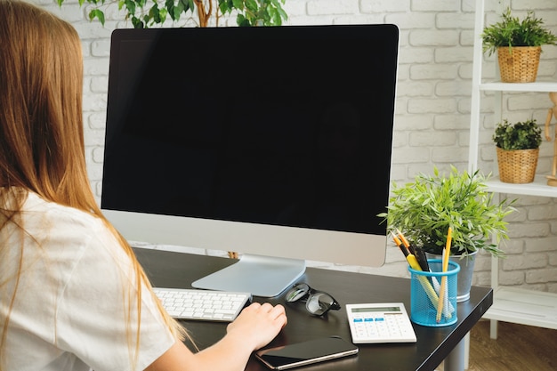 Empresaria usando su computadora en una oficina o en casa