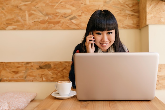 La empresaria usando su computadora portátil en la cafetería. Concepto de negocio