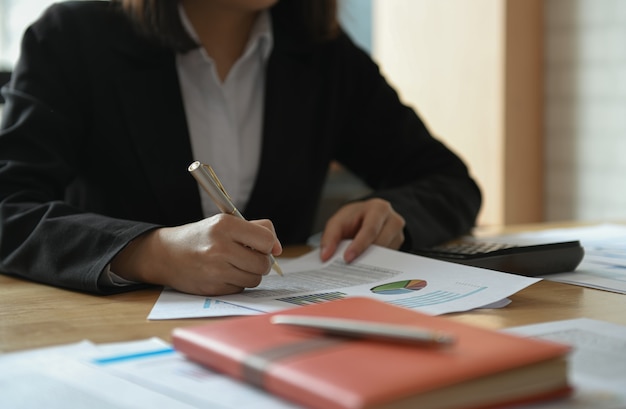 Empresárias estão trabalhando na mesa do escritório. Ela apontou o gráfico para analisar.