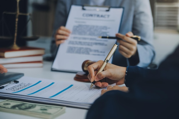 Foto empresario y abogado discuten el documento del contrato tratado de la ley firmar un contrato de negocios