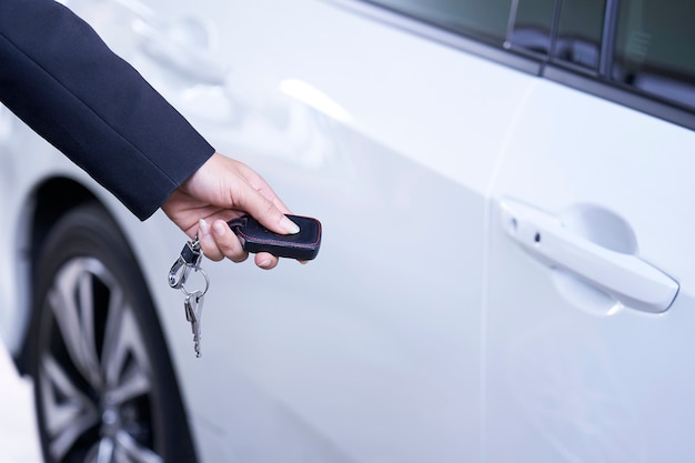 Empresário abre a porta do carro com controle remoto.