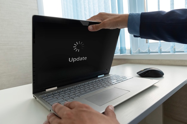 Foto el empresario abre un ultrabook moderno en el que se actualiza el sistema operativo. actualización del concepto de actualización de tecnología de software