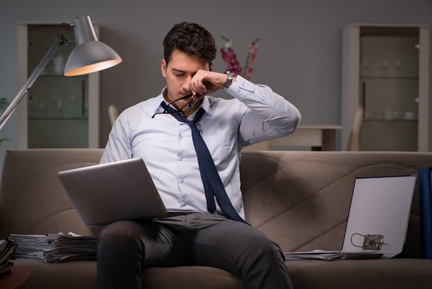 Empresario adicto al trabajo trabajando hasta tarde en casa