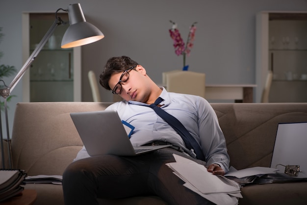 Empresario adicto al trabajo trabajando hasta tarde en casa