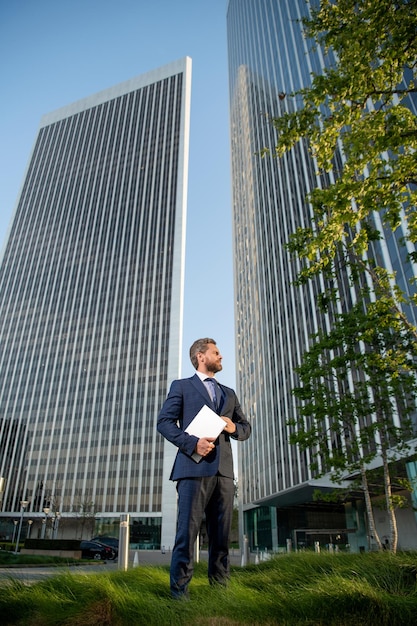 Empresario administrador de red profesional de negocios ágil mantener jefe de computadora con portátil inalámbrico moderno hombre de negocios de cuerpo entero fuera de la oficina gerente de éxito empresarial hombre mantener pc