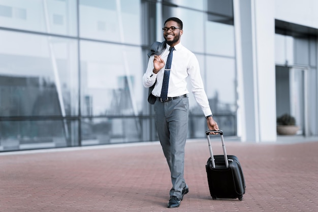 Empresário afro-americano andando com mala no aeroporto