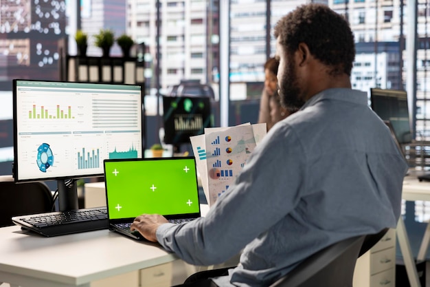 Empresario afroamericano en la oficina con una maqueta de pantalla analizando datos