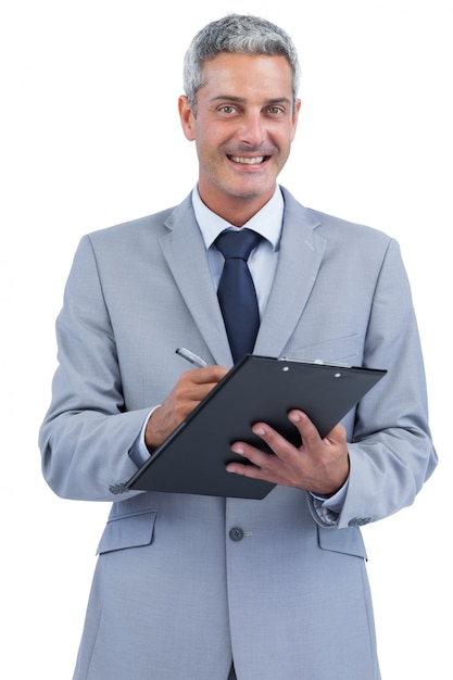 Foto empresário alegre segurando prancheta e tomando notas