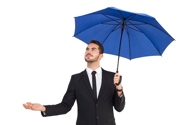 Empresario alegre sosteniendo el paraguas con la mano