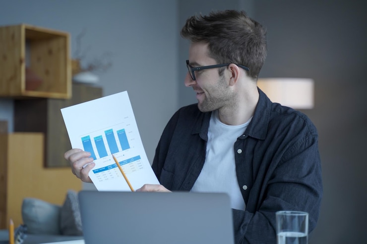 Foto empresario alemán sonriente con gafas que representan gráficos de resultados e ingresos en una cámara portátil