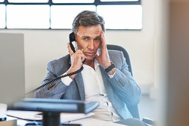 Empresario de alto nivel dolor de cabeza estrés y llamada telefónica comunicación en línea y ansiedad de los empleados en la oficina Conversación de llamada telefónica de hombre frustrado y malestar por conflicto de red con dolor de cabeza