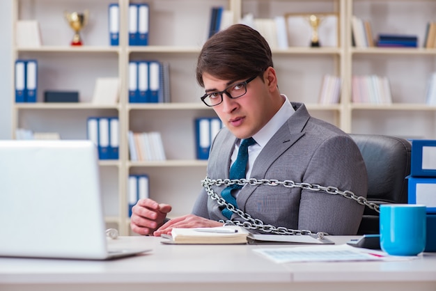 Empresário amarrado com correntes para o seu trabalho