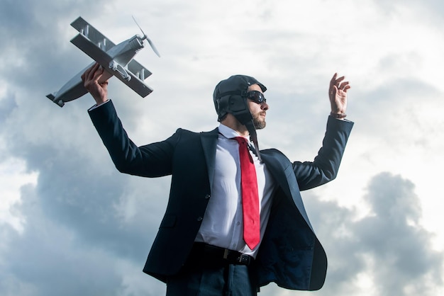 Empresário ambicioso de terno e brinquedo de avião de lançamento de chapéu piloto