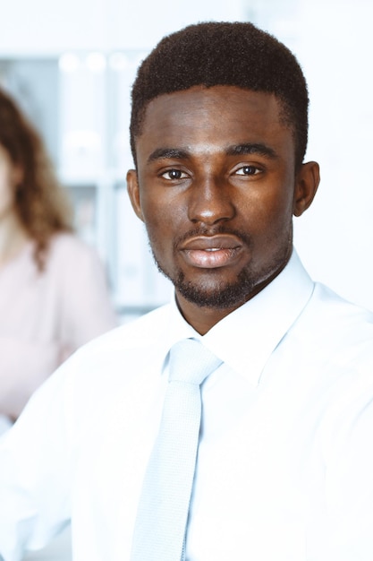 Empresário americano africano em reunião no escritório, colorido de branco. Grupo de empresários multiétnicos.