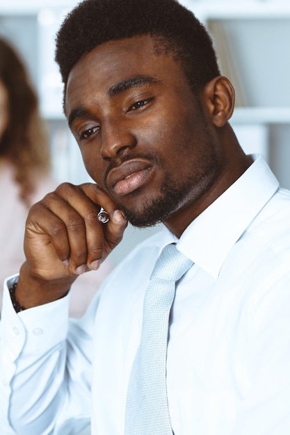 Empresário americano africano em reunião no escritório, colorido de branco. Grupo de empresários multiétnicos.