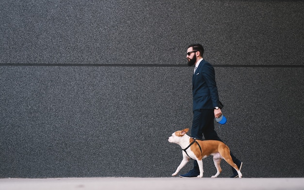 Empresário andando com cachorro na rua