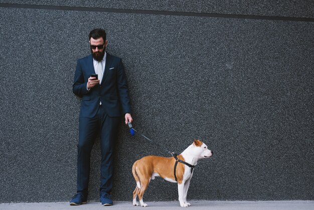 Empresário andando com cachorro na rua