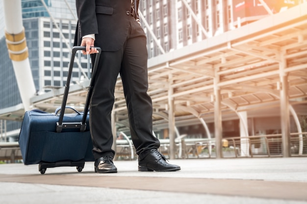 Empresário andando no caminho para o aeroporto com bagagem