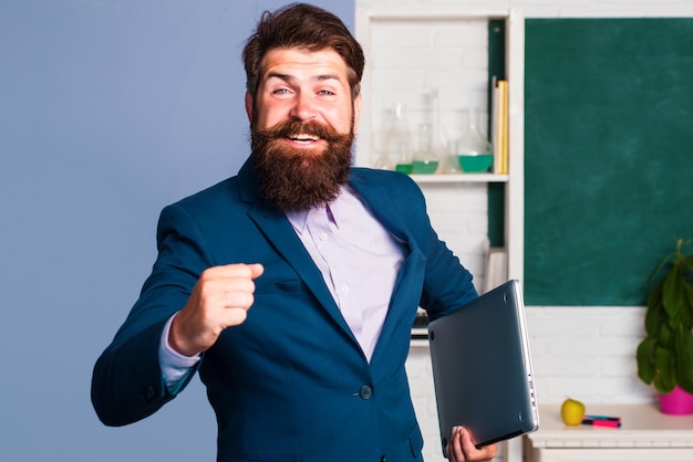 Empresário animado, professor profissional, empresário hipster, rindo da sala de aula da escola, espantado