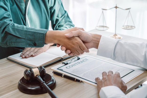 Empresário apertando as mãos com advogado profissional depois de discutir um bom contrato no tribunal, aperto de mão após boa cooperação.