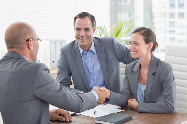 Empresário apertando as mãos com uma empresária